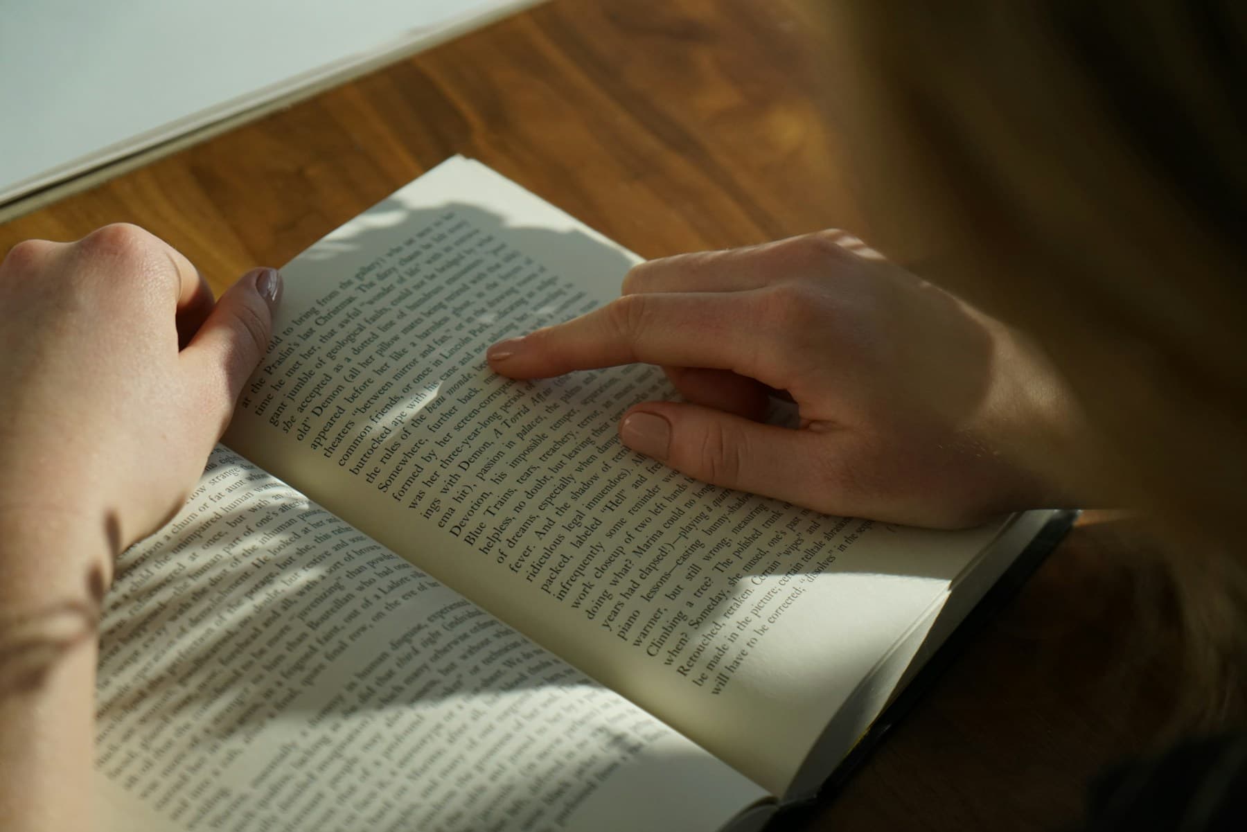 Gün ışığında açık bir kitap okuyan kişi